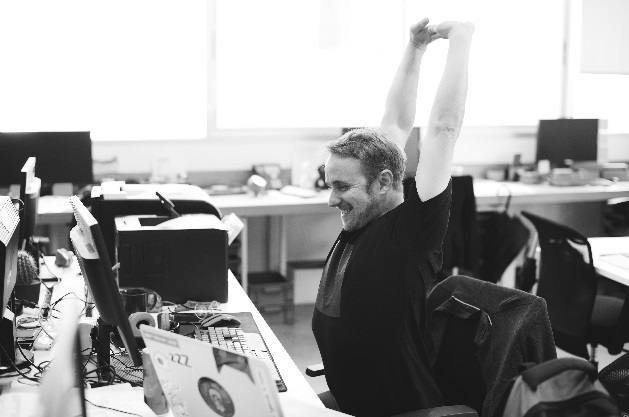Man happily stretching at work